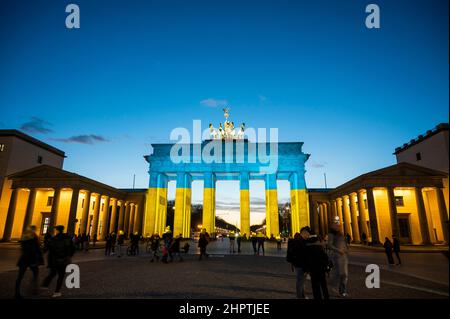 Berlino, Germania. 23rd Feb 2022. La porta di Brandeburgo è illuminata nei colori della bandiera Ucraina. Credit: Christophe Gateau/dpa/Alamy Live News Foto Stock