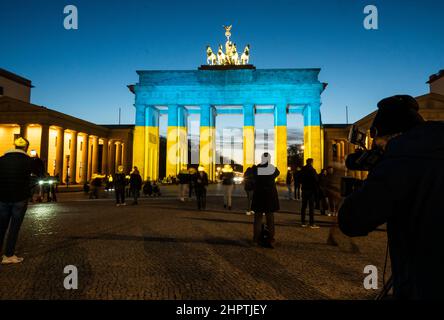 Berlino, Germania. 23rd Feb 2022. La porta di Brandeburgo è illuminata nei colori della bandiera Ucraina. Credit: Christophe Gateau/dpa/Alamy Live News Foto Stock