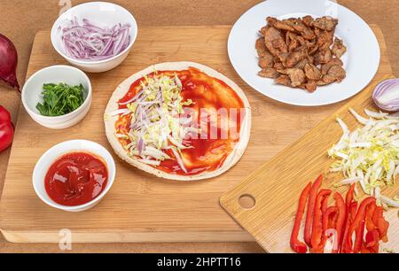 Pita con ketchup, lattuga e cipolla tritata. Kebab fatto in casa. Foto Stock