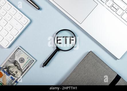 Concetto di investimento ETF. Abbreviazione tramite lente di ingrandimento sulla scrivania dell'ufficio, foto Foto Stock