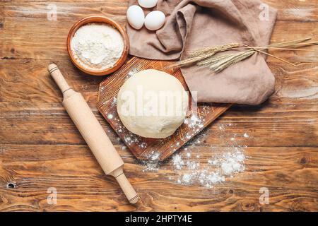 Pasta cruda con farina, laminello e uova su sfondo di legno Foto Stock
