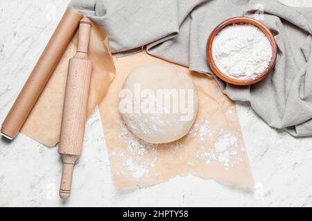 Pasta cruda con farina e spilla su sfondo chiaro Foto Stock