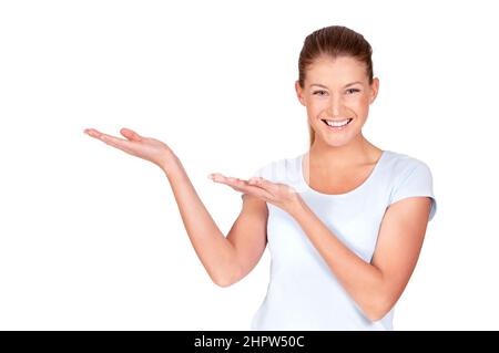 Sostengo pienamente questo come impressionante. Una donna piuttosto giovane che presenta qualcosa a voi mentre isolato su bianco. Foto Stock