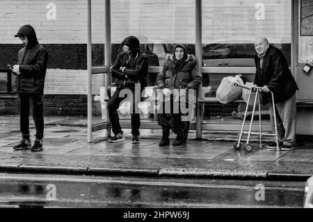 Fotografia di strada, persone in attesa di un autobus a Green Street, Upton Park, Newham Foto Stock