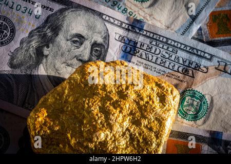 Naturale oro Nuggets su centinaia dollari bollette. Investite in oro reale che in oro. Primo piano Gold finanza ricchezza o risparmio. Concetto finanziario Foto Stock