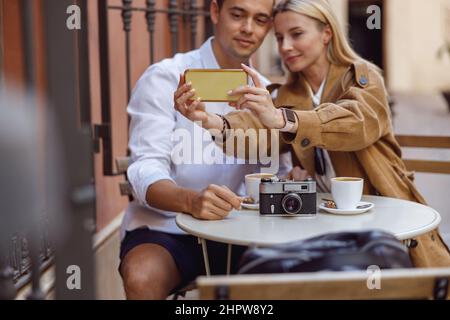 Primo piano di una donna che tiene lo smartphone mentre prende selfie Foto Stock