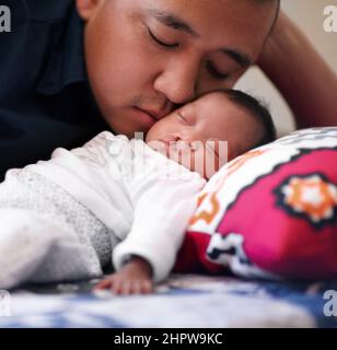 Sotto lo sguardo amorevole del padre. Scatto di un giovane padre che si lega con la sua bambina che ha un palato di ciglia. Foto Stock