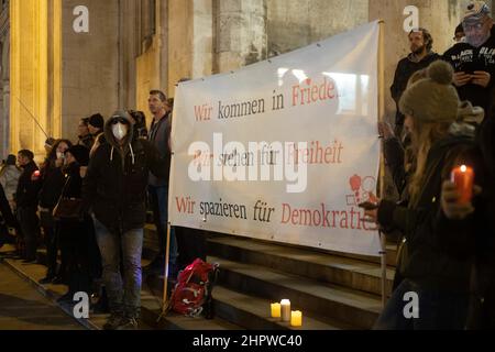 Monaco di Baviera, Germania. 23rd Feb 2022. Partecipanti con il banner: "Noi veniamo in pace, noi siamo per la libertà, camminiamo per la democrazia. Il 23 febbraio 2022, centinaia di antivasseri si sono riuniti per dimostrare di essere contrari alla vaccinazione obbligatoria e alle misure di protezione covidi. Si allinearono tra la Geschwister-Scholl-Platz e Odeonsplatz per formare una catena di luci. L'obbligo di maschera e le regole di distanza sono state mantenute a malapena. (Foto di Alexander Pohl/Sipa USA) Credit: Sipa USA/Alamy Live News Foto Stock