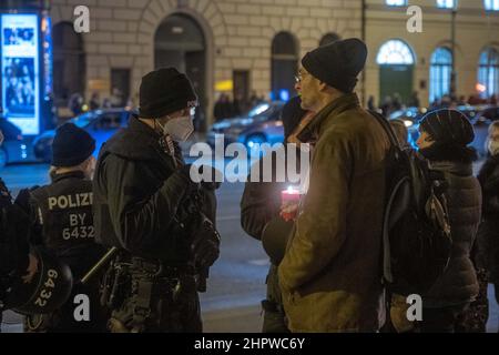 Monaco di Baviera, Germania. 23rd Feb 2022. I partecipanti discutono con la polizia. Il 23 febbraio 2022, centinaia di antivasseri si sono riuniti per dimostrare di essere contrari alla vaccinazione obbligatoria e alle misure di protezione covidi. Si allinearono tra la Geschwister-Scholl-Platz e Odeonsplatz per formare una catena di luci. L'obbligo di maschera e le regole di distanza sono state mantenute a malapena. (Foto di Alexander Pohl/Sipa USA) Credit: Sipa USA/Alamy Live News Foto Stock