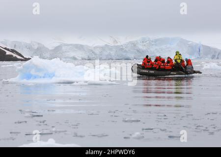 I passeggeri della crociera da le Boreal attraversano le acque ghiacciate di Paradise Bay in una barca zodiacale, appena a est dell'Isola di Bryde, Antartide. Foto Stock