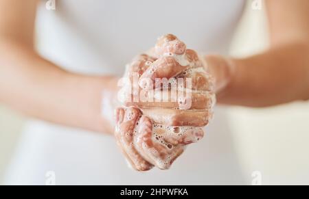 Tenere pulito e al sicuro dai germi. Primo piano di una donna lavando le mani con sapone. Foto Stock