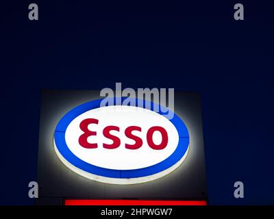 Il logo esso è visto fuori da una stazione di servizio di notte. Foto Stock