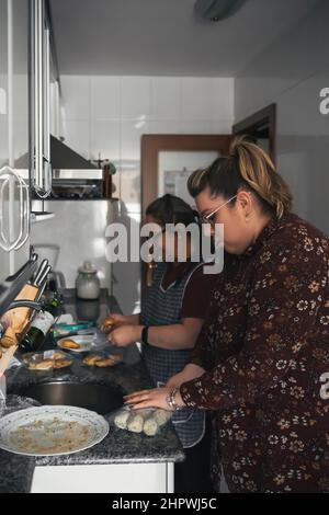 madre anziana che insegna a sua figlia come cucinare Foto Stock