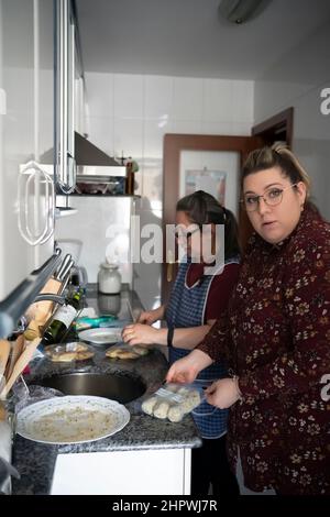 madre anziana che insegna a sua figlia come cucinare Foto Stock