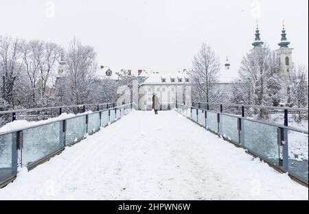 Paesaggio invernale con la chiesa Mariahilfer sullo sfondo, nel centro della città di Graz, regione Steiermark, Austria, in una bella giornata di neve Foto Stock