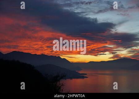 Nuvole rosse incandescenti nel cielo della sera, tramonto sul Lago maggiore, Luino, Lombardia, Italia Foto Stock