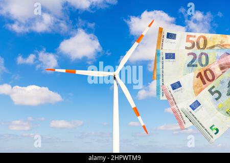 Fotomontaggio, immagine simbolica costi di energia, parco eolico, banconote, nuvole, transizione energetica, energia rinnovabile, cielo nuvoloso Foto Stock