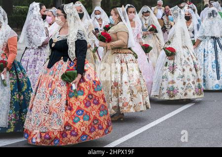 Valencia, Spagna - 4 settembre 2021: Sfilata del gruppo di celebrazione 'Fallas' indossando abiti tradizionali e maschere facciali Foto Stock