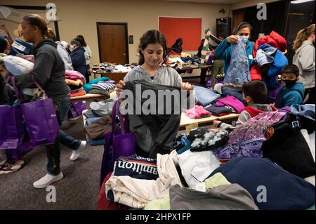 Marietta, Georgia, Stati Uniti. 13th Feb 2022. Una donna esamina una maglietta da pile di abiti donati alla First Baptist Church di Marietta, Georgia, durante una cena per individui o famiglie che stanno lottando finanziariamente o senzatetto. (Credit Image: © Robin Rayne/ZUMA Press Wire) Foto Stock