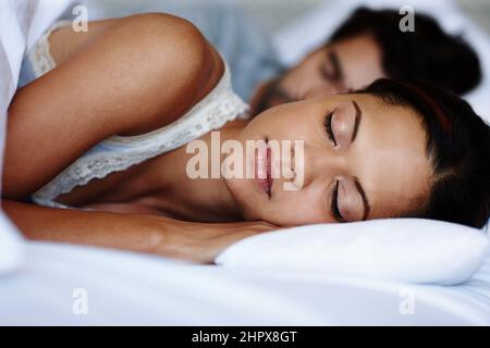 Sognare via. Una giovane coppia carina che dorme a letto insieme. Foto Stock