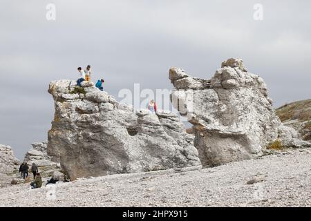 Faro, Svezia - 3 ottobre 2020: Un gruppo di tre persone che visitano l'area delle cataste marine di Langhammar. Foto Stock