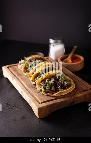 Tacos de Suadero. Carne fritta in una tortilla di mais. Street food di CDMX, Messico, tradizionalmente accompagnato da coriandolo, cipolla e salsa rossa piccante Foto Stock