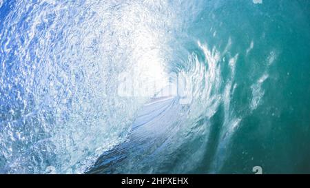 Onde oceaniche cave che precipita l'acqua di mare su una barriera corallina poco profonda con retro-luce sole primo piano nuoto foto in natura potere Foto Stock