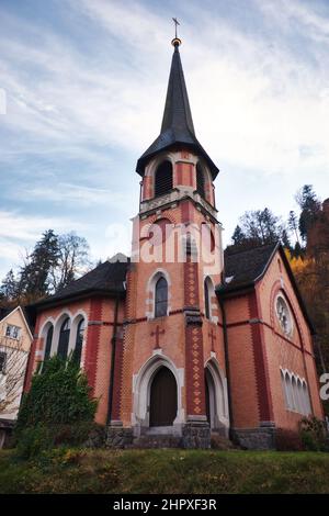 Piccola chiesa evangelica Trinitatis con nuvole bianche nel cielo in un giorno autunnale a Triberg, Germania. Foto Stock