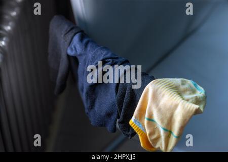 raccolta di calze lavate che asciugano su una sedia maniglia accanto ad un radiatore, closeup interno Foto Stock