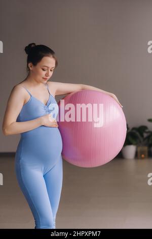 Donna incinta durante le lezioni di fitness con un fit ball. Foto Stock