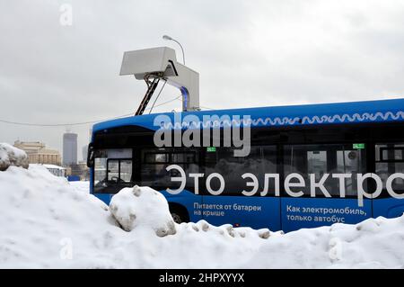 Bus elettrico alla stazione di ricarica durante la ricarica. Lavorare in condizioni invernali difficili. Foto Stock