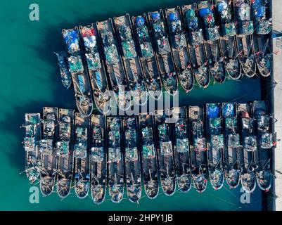 QINGDAO, CINA - 23 FEBBRAIO 2022 - una foto aerea scattata il 23 febbraio 2022 mostra i pescherecci che si riuniscono al porto di pescatori di Jimiya a Qingdao, Est Foto Stock