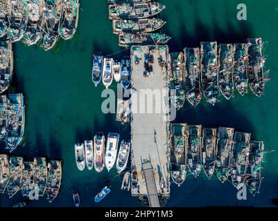 QINGDAO, CINA - 23 FEBBRAIO 2022 - una foto aerea scattata il 23 febbraio 2022 mostra i pescherecci che si riuniscono al porto di pescatori di Jimiya a Qingdao, Est Foto Stock