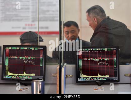 Shanghai Index visto visualizzato su monitor, mentre in background tre uomini parlano del flusso di borsa. Sotto l'influenza della guerra Russia-Ucraina, il mercato cinese delle azioni A un tempo vide transazioni di panico. Il fatturato dei due mercati superava presto i trilioni di yuan, e alla fine del volume di negoziazione superava i 1,3 trilioni di yuan, un massimo di 5 mesi. Alla fine del trading, l'indice di Shanghai era a 3429 punti, in calo del 1,7%, l'indice di Shenzhen a 13252 punti, in calo del 2,2%, l'indice di gemme a 2783 punti, in calo del 2,11%. Foto Stock