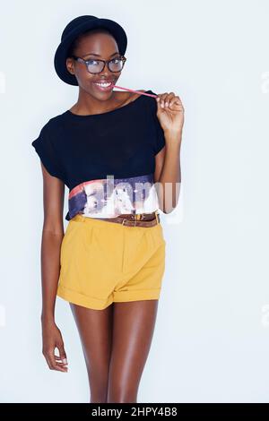 Esprimendo il suo lato del bambino. Una giovane donna che si posa contro il bianco. Foto Stock