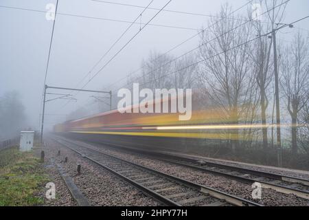 Immagine sfocata di un treno merci su una pista ferroviaria nebbia vicino Margaretting Essex Foto Stock