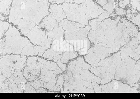 Incrinature sulla superficie di calcestruzzo bianco incrinature cemento resistente agli agenti atmosferici usura struttura rotta astratto danneggiato sfondo del modello. Foto Stock