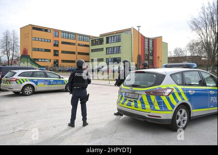 Petersberg, Germania. 24th Feb 2022. Ufficiali di polizia armati assicurano la zona intorno ad un edificio scolastico nel villaggio di Wallwitz nel comune di Petersberg come precauzione. Nella scuola di Petersberg, nel distretto di Saale, e nei dintorni, giovedì mattina è stata effettuata un'operazione di polizia su larga scala. Secondo la polizia, c'era stata un'esplosione di un oggetto pirotecnico. (Alla dpa 'operazione major a scuola in Petersberg - polizia dare tutto-chiaro') Credit: Heiko Rebsch/dpa-Zentralbild/dpa/Alamy Live News Foto Stock