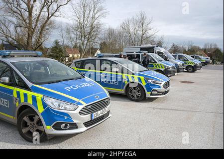 Petersberg, Germania. 24th Feb 2022. I veicoli della polizia si trovano sul terreno di fronte ad un edificio scolastico nel villaggio di Wallwitz nel comune di Petersberg. Nella scuola di Petersberg, nel distretto di Saale, giovedì mattina è stata effettuata un'operazione di polizia su larga scala. Secondo la polizia, c'era stata un'esplosione di un oggetto pirotecnico. (Alla dpa 'operazione major a scuola in Petersberg - polizia dare tutto-chiaro') Credit: Heiko Rebsch/dpa-Zentralbild/dpa/Alamy Live News Foto Stock