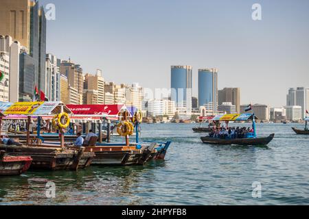 I turisti attraversano il Dubai Creek in una tradizionale barca abra nella città di Dubai, Emirati Arabi Uniti. Foto Stock