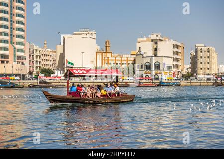 I turisti attraversano il Dubai Creek in una tradizionale barca abra nella città di Dubai, Emirati Arabi Uniti. Foto Stock