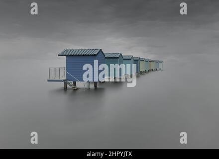 Moody lunga esposizione di capanna di spiaggia in Essex Foto Stock