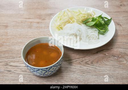 spaghetti di riso conditi con salsa al curry di pesce con palla di carne e verdure fresche sul piatto Foto Stock