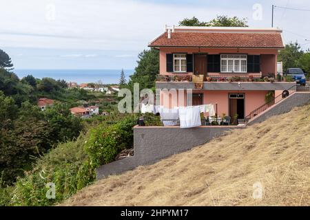 SANTANA, PORTOGALLO - 21 AGOSTO 2021: Si tratta di una delle case residenziali dell'altopiano, costruita su un pendio ripido. Foto Stock