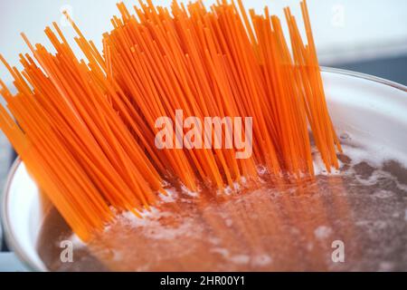 Pasta di lenticchie rosse senza glutine bollente in una pentola. Primo piano. Foto Stock