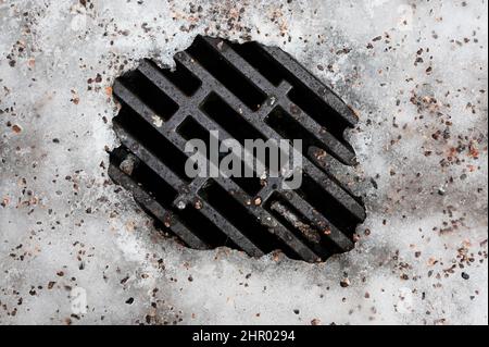 tempesta fogna tombola con ghiaccio in inverno Foto Stock