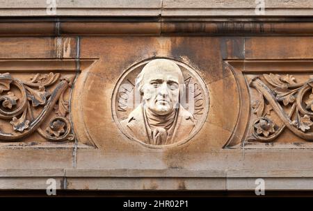 Su un muro esterno al Gonville & Caius College, università di Cambridge, Inghilterra, un busto di ex studente, William Hyde Wollaston (1766–1828) chimico. Foto Stock