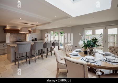 Eccezionale lussuosa ed elegante sala da colazione con cucina attrezzata con elettrodomestici incorporati, tra cui fornelli e ripiani in marmo di granito, imbottiti Foto Stock