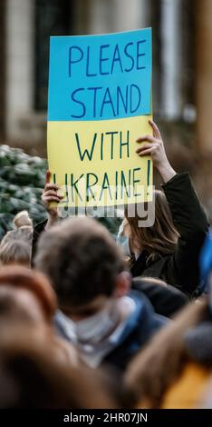 Amburgo, Germania. 23rd Feb 2022. Un dimostratore ha un cartello con la scritta "Please stand ith Ukraine" ad un raduno di fronte al Consolato Generale della Federazione Russa ad Amburgo contro la politica Ucraina della Russia. Credit: Markus Scholz/dpa//dpa/Alamy Live News Foto Stock