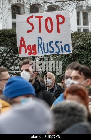 Amburgo, Germania. 23rd Feb 2022. Un dimostratore ha un cartello con la scritta "Stop AggRussia" in un raduno davanti al Consolato Generale della Federazione Russa ad Amburgo contro la politica Ucraina della Russia . Credit: Markus Scholz/dpa//dpa/Alamy Live News Foto Stock